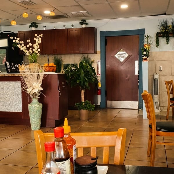 Gao Restaurant interior with a service counter, dining tables, and customers under warm string lights.